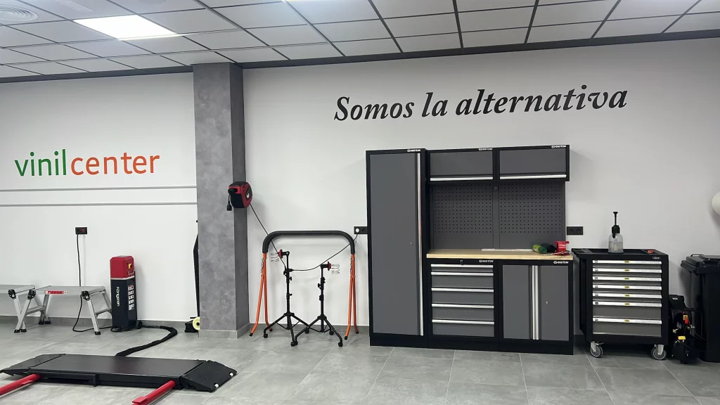 Zona de trabajo del taller de Vinilcenter con banco de herramientas y elevador