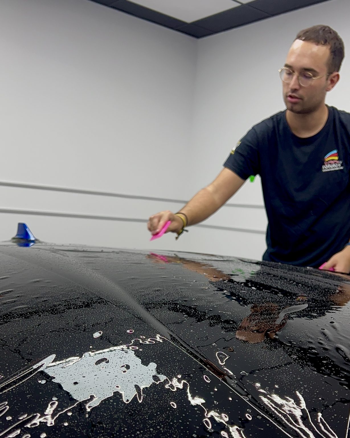 Instalador de Vinilcenter colocando film de protección de pintura en un coche negro