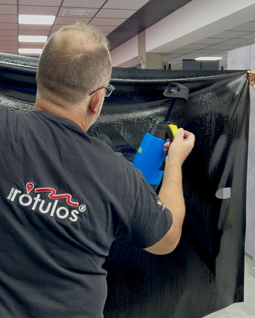 Aplicación del vinilo azul con espátula sobre el lateral