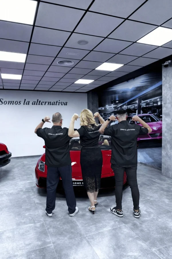 El equipo de Vinilcenter de espaldas frente a un coche en el taller