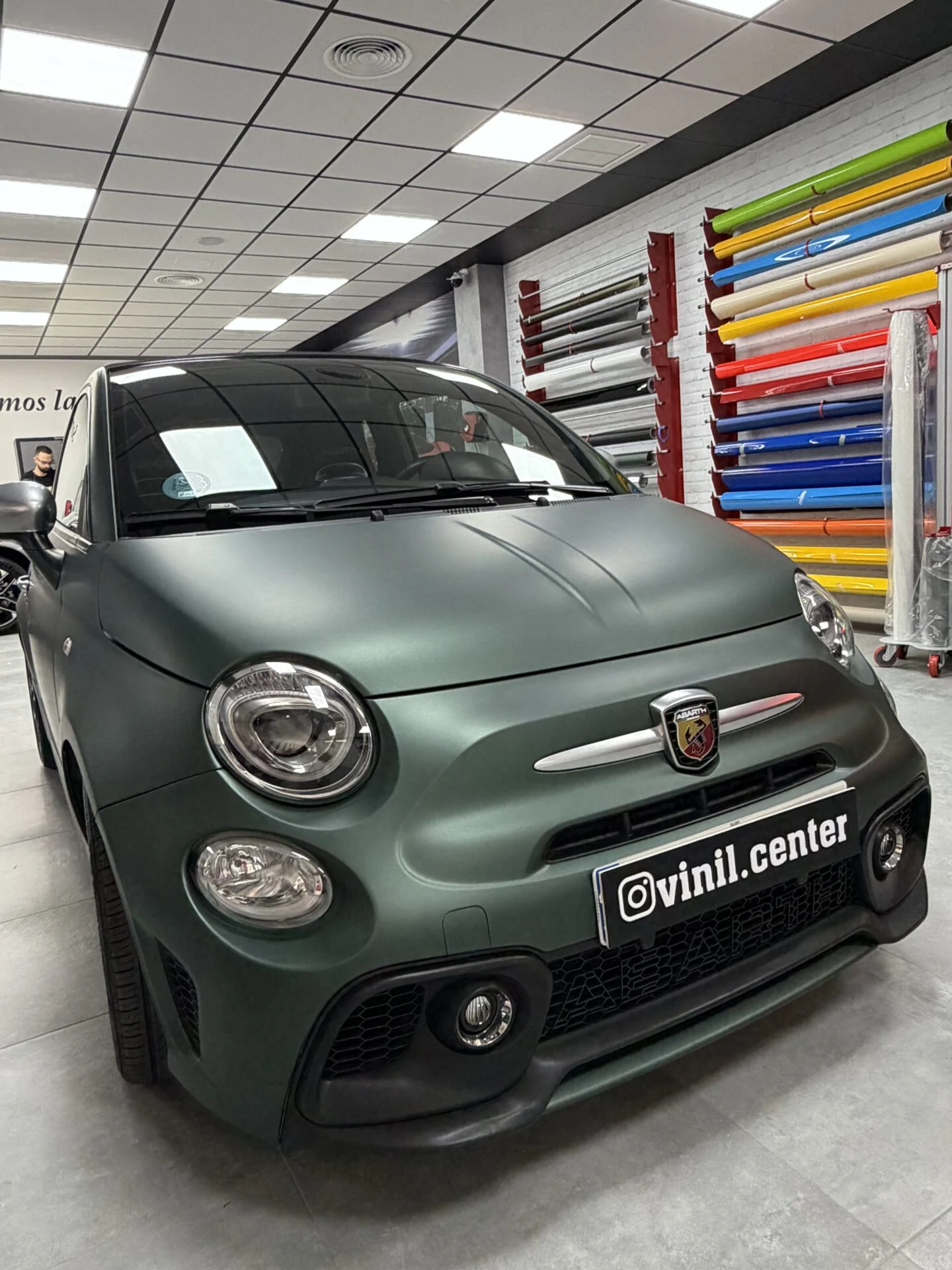 Vista tres cuartos del Abarth 595 vinilado en verde militar mate en el taller de VinilCenter