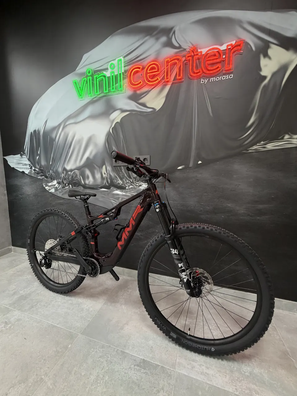 e-MTB de doble suspensión protegida con PPF delante del rótulo de Vinilcenter en el taller de Murcia