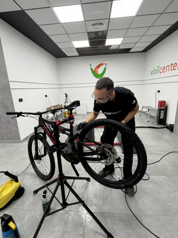Bicicleta de montaña en el soporte del taller mientras se le aplica PPF